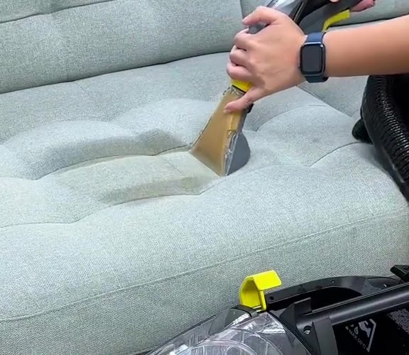 Same sofa seat after extraction, stain lifted, dirty water in the nozzle